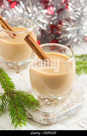 Eggnog with cinnamon sticks, Christmas decoration and ornaments over white background - homemade festive Christmas alcoholic Stock Photo