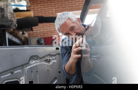 focusing auto body worker examining panel car Stock Photo - Alamy