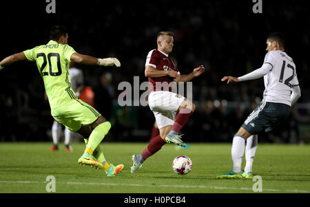 Northampton Town's Sam Hoskins (centre) battles for the ball with Manchester United goalkeeper Sergio Romero (left) and Manchester United's Chris Smalling (right) during the EFL Cup, Third Round match at Sixfields Stadium, Northampton. Stock Photo