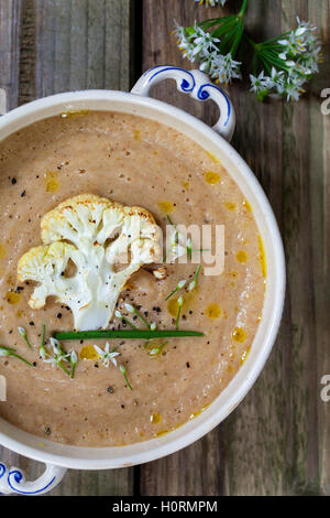 Roast cauliflower soup with wild garlic flowers Stock Photo