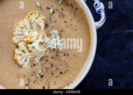 Roast cauliflower soup with wild garlic flowers Stock Photo