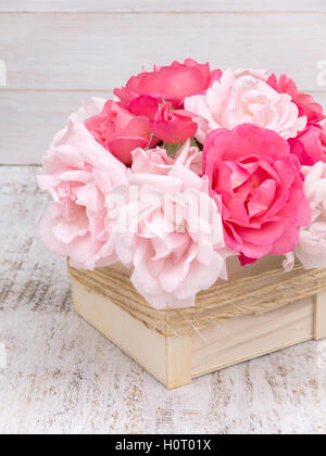 Pink and pale pink roses bouquet in the wooden box tied with jute rope Stock Photo