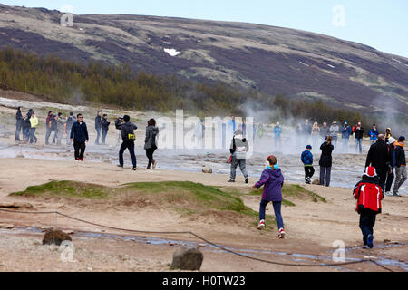 tourists stand around waiting for the strokkur geyser to erupt geysir Iceland Stock Photo