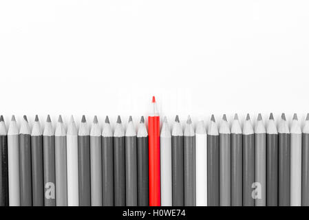 Red pencil standing out from monochrome pencils crowd, copy space available. Stand out from the crowd concept Stock Photo