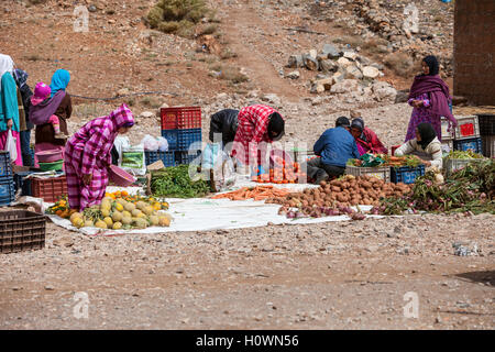 Atlas Mountains, Morocco.  Market Scene in Berber Village near Dades Gorge.  Women Choosing Vegetables and Melons. Stock Photo