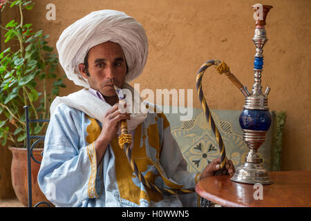 Near Ait Oudinar, Dades Gorge, Morocco.  Young Berber Man Smoking a Hookah (Shisha). Stock Photo