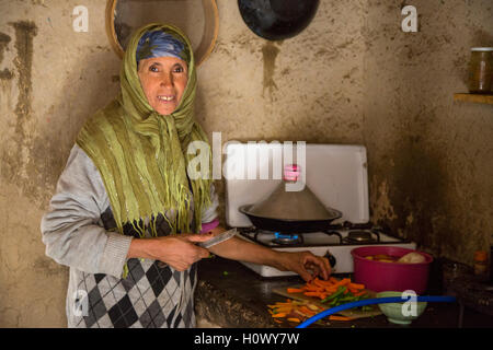 Dades Gorge, Morocco.  Middle-aged Berber Woman Preparing Dinner in her Kitchen. Stock Photo