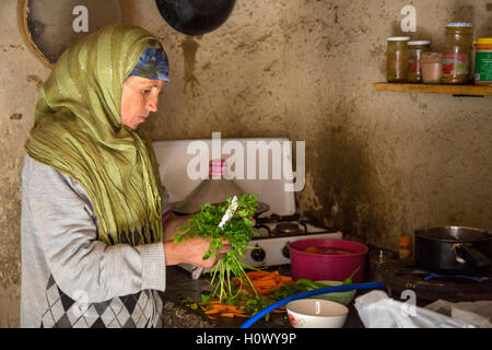 Dades Gorge, Morocco.  Middle-aged Berber Woman Preparing Dinner in her Kitchen. Stock Photo