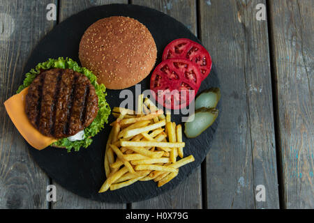 Beef hamburger grill french fries pickled cucumber tomato cheese Stock Photo