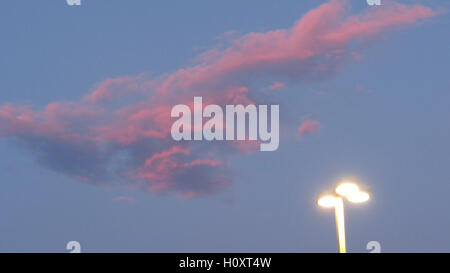 Red clouds and street lamp in dark blue sky at sunset Stock Photo