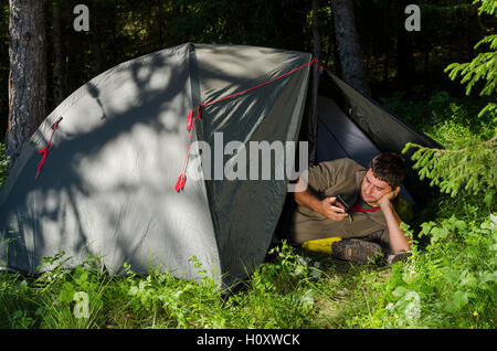 Texting message using my smart phone in the forest Stock Photo