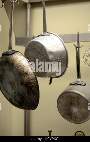 Pots and pans hanging in a professional restaurant kitchen Stock Photo