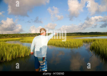 An inshore charter guide searches flats on Florida's pristine Intercoastal waterway for signs of redfish on flood tide. Stock Photo