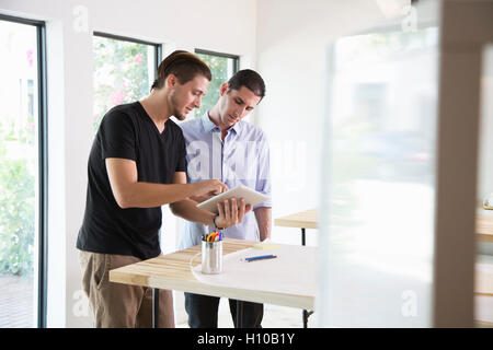 Two male office workers discuss ideas in a modern office Stock Photo