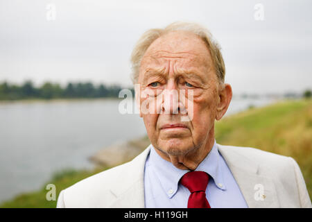 senior man 80 posing in front of river, close up shot in summer, thoughtful look Stock Photo