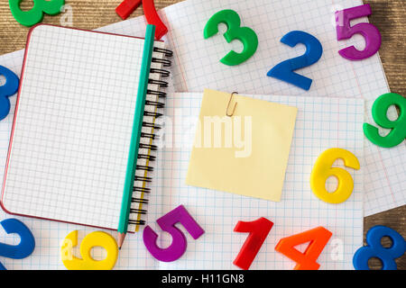 Squared exercise book,personal organizer,colored numbers and blank sticky note Stock Photo