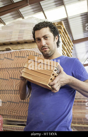 Worker with bricks in construction workshop Stock Photo