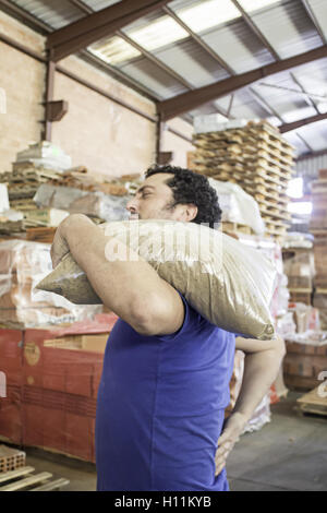 Young man carrying cement factory interior construction Stock Photo