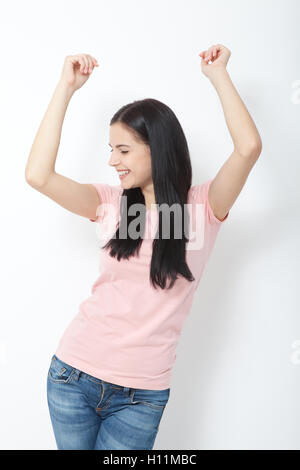 Portrait of happy young woman dancing on white background Stock Photo
