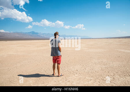 Young man looking across vast landscape, Death Valley, Death Valley National Park, California, USA Stock Photo