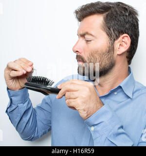 Brunette man checking his hairbrush losing hair Stock Photo