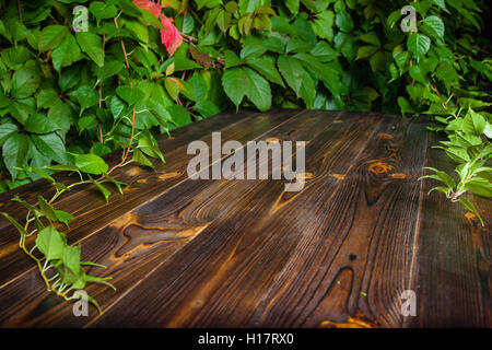 Horizontal wooden background made of planks framed by autumn leaves Stock Photo
