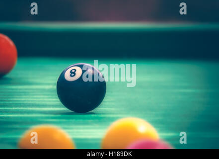 Black billard ball number eight on green billard table Stock Photo