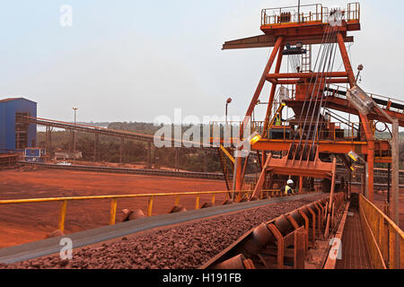 Port operations for transporting and managing iron ore. On Butterfly Stacker showing conveyor moving lump ore from train to stockpile before shipping. Stock Photo