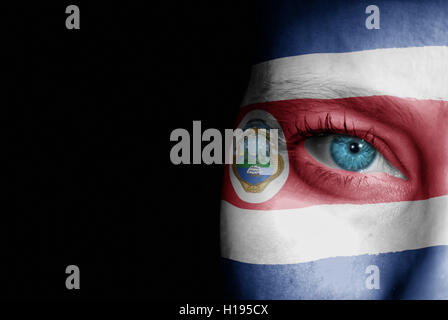 A young female with the flag of Costa Rica painted on her face on her way to a sporting event to show her support. Stock Photo