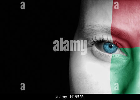 A young female with the flag of Madagascar painted on her face on her way to a sporting event to show her support. Stock Photo