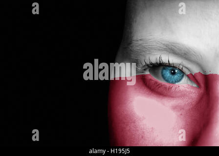 A young female with the flag of Poland painted on her face on her way to a sporting event to show her support. Stock Photo