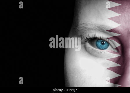 A young female with the flag of Qatar painted on her face on her way to a sporting event to show her support. Stock Photo