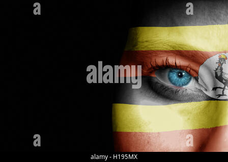 A young female with the flag of Uganda painted on her face on her way to a sporting event to show her support. Stock Photo