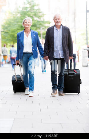 Senior couple with  suitcases Stock Photo