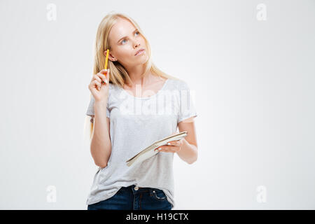 Serious pensive young girl making notes in the notebook isolated on the white background Stock Photo