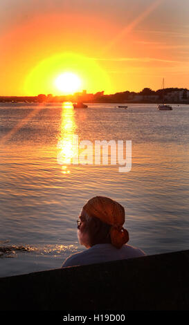 Stunning sea sunset, man watching the sunsetting on the sea, Mudeford quay, Dorset, UK. Stock Photo