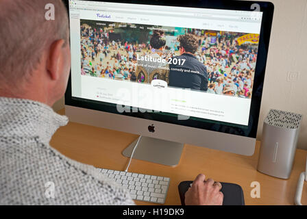 Man person looking at Latitude Festival website on computer screen England UK United Kingdom GB Great Britain Stock Photo