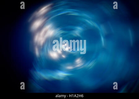 Spinning vortex effect on the surface of a pool of bright blue water Stock Photo