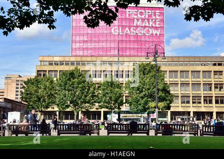 Glasgow, Scotland, UK. 22nd September, 2016. People enjoy the autumn sunshine on the benches in George Square, with the Ciy of Glasgow College in the background, with People Make Glasgow slogan. Credit:  Tony Clerkson/Alamy Live News Stock Photo