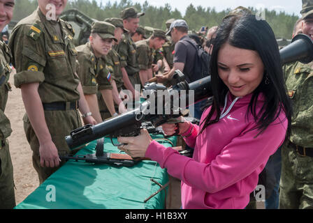 Girl considers the RPG-7 grenade launcher Stock Photo
