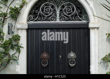 Varenna, Italy - September 4th, 2015: closeup photo of a black door with elaborate handles at Villa Monastero in Varenna, Italy. Stock Photo