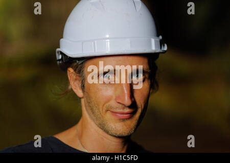 portrait of a worker with white helmet on head,  nature background Stock Photo