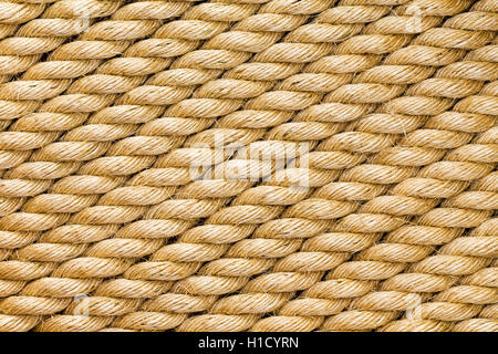 Diagonal strands of a new thick sisal and hemp rope with twisted braided fibers in a full frame close up background texture Stock Photo