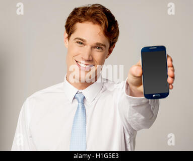 Salesman displaying newly launched mobile Stock Photo