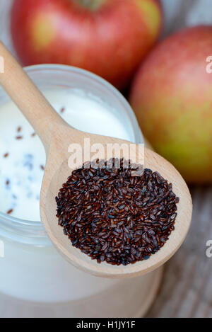 Flohsamen-Wegerich in Kochloeffel auf Joghurtglas und Aepfel, Plantago psyllium Stock Photo