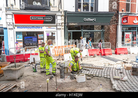 Workmen laying new pedestrian surface in centre of Abergavenny, Wales, UK Stock Photo