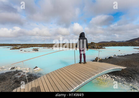 Tourist on a wooden bridge at the Blue Lagoon near Gratdavik, West Iceland, Iceland Stock Photo