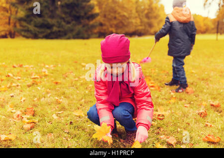 children collecting leaves in autumn park