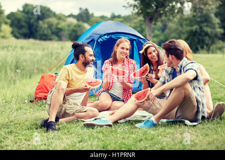 happy friends eating watermelon at camping Stock Photo