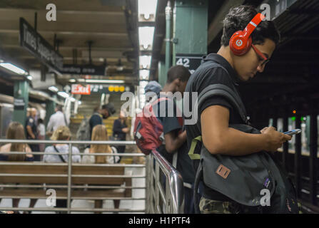 A distracted music listener wears his Beats by Dr. Dre over the ear headphones on a subway platform in New York on Thursday, September 22, 2016. (© Richard B. Levine) Stock Photo